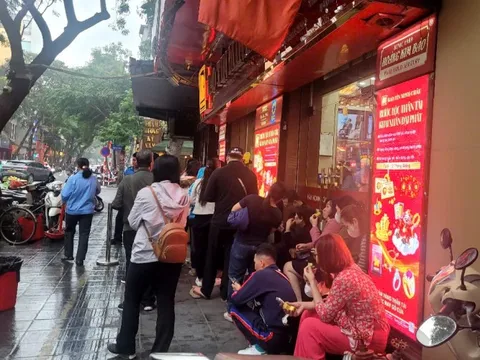 Người dân đội mưa xếp hàng chờ mua vàng trước ngày vía Thần Tài